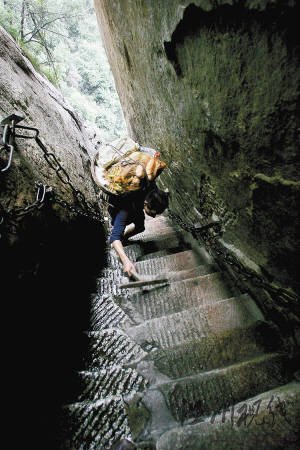 华山第一险道“千尺幢”与地面几乎呈80度，何天武背着60多斤的菜，一只手还要拿着拐杖，只能艰难爬行。