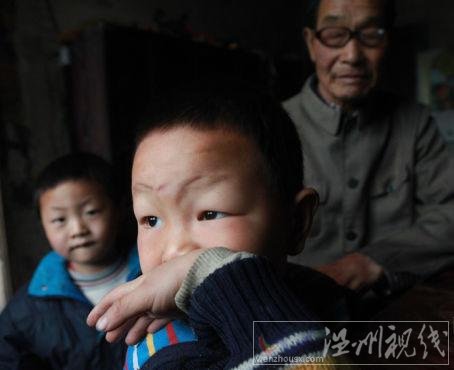 毛坪村的小男孩袁石(中)，告诉记者，他的妹妹袁丽一岁的时候，被抢走了，至今下落不明。他想念妹妹，多次梦到她回家了。 记者 李漠 摄
