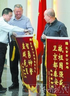5月13日，故宫博物院负责人来到北京市公安局，向快速侦破故宫失窃案的市局有关部门赠送锦旗。锦旗中的“撼”字应为“捍”。本报记者 贾同军摄 