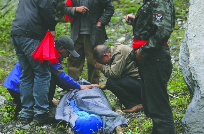 女驴友遇难，警民抬担架遇难者遗体出山