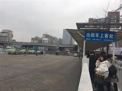 火车北站出租车上客处，一边是排起长队的乘客，一边是寥寥可数的出租车。