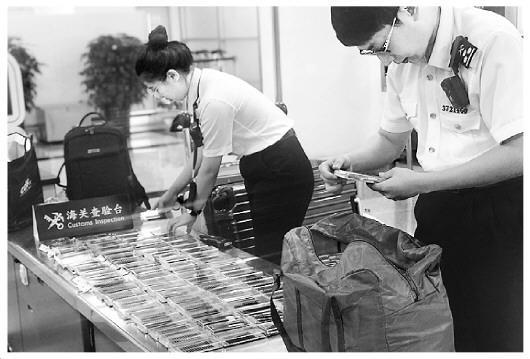 图为海关工作人员在检查旅客携带的假睫毛。王咏洁 摄 